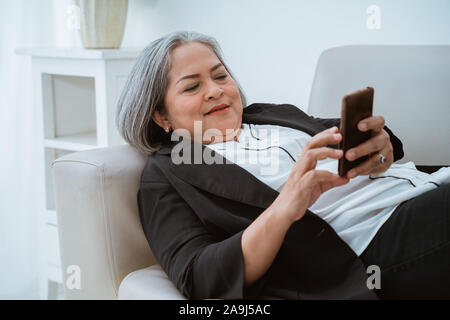 Fiducioso vecchia donna casualmente gestisce la sua azienda Foto Stock