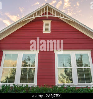 Quadrato Rosso colorato rivestito di legno casa in giorno Foto Stock