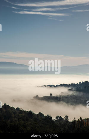 Surreale in vista di una piccola città in Umbria (Italia) quasi completamente nascosto dalla nebbia Foto Stock