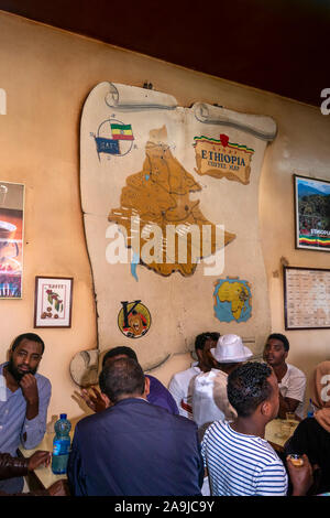Etiopia, Addis Abeba, Piazza Area, Cafe ToMoCa coffee shop, uomini di bere al di sotto di mappa che mostra le aree di produzione Foto Stock