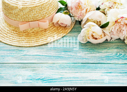 Estate vacanze sfondo. Peonie rosa e il cappello di paglia Foto Stock