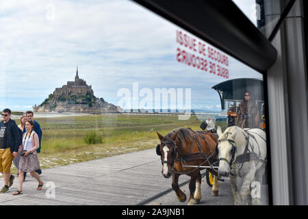 MONT SAINT MICHEL, Francia - luglio 3, 2017: i turisti possono scegliere diversi mezzi di trasporto, a piedi, in autobus o in carrozza trainata da cavalli. Non è possi Foto Stock