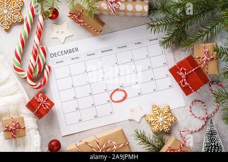 Pagina pianificatore con Natale confezioni regalo e decorazione intorno a. 25 dicembre contrassegnato con un cerchio rosso sul calendario. Xmas concetto di preparazione. Foto Stock