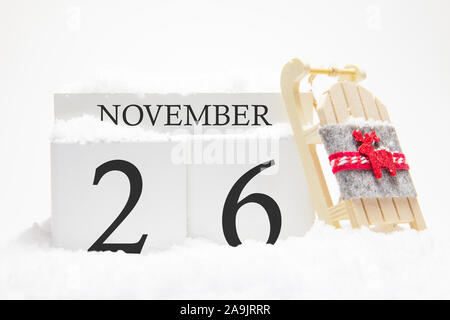 Calendario di autunno fatta di cubi di legno con la data del 26 novembre, il concetto della prima neve e vacanze in futuro. Close-up. Foto Stock