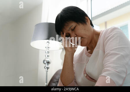 Vecchia donna che soffre di mal di testa e stress, emicrania, problema di salute concetto Foto Stock