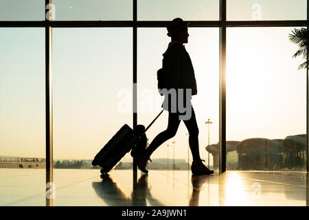 viaggiatore a piedi con la valigia, passeggero per un tour nel terminal dell'aeroporto per il viaggio in aereo Foto Stock