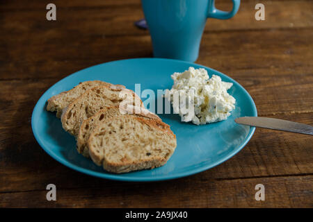 Colazione tostare il pane su una piastra blu con formaggio morbido Foto Stock