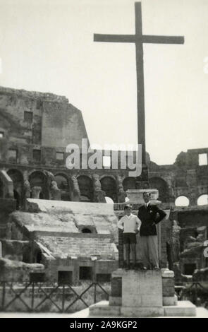 Padre e figlio all'interno del Colosseo con una croce in background, Roma, Italia Foto Stock