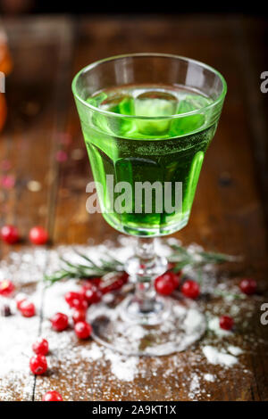 L'assenzio è versata in un bel vecchio vetro, sorge sul banco bar Sugar è splendidamente cosparso vicino al vetro e bacche rosse giacciono Foto Stock