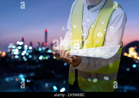 La doppia esposizione di ingegnere azienda walkie talkie sono gli ordini di lavorazione del petrolio e del gas impianto di raffineria. L'industria petrolchimica Concetto di immagine e l'icona con Foto Stock