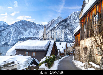 Classica vista da cartolina della famosa città sul lago di Hallstatt nelle Alpi in una bella giornata di sole con cielo blu e nuvole in inverno, Austria Foto Stock