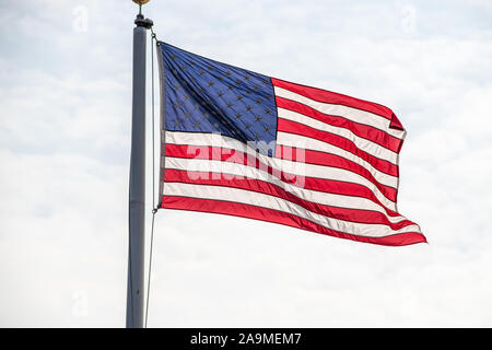 Bandiera americana battenti in vento sul pennone contro il cielo nuvoloso Foto Stock