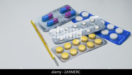 Close up di termometro, compresse e capsule isolati su sfondo bianco. Foto Stock