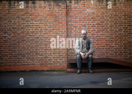 Una più grande di vita della statua di Sean Henry in Woking stazione ferroviaria, Surrey Foto Stock