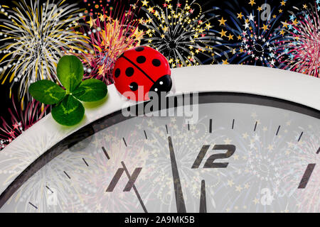 Concetto di festa di Capodanno con orologio e fuochi d'artificio Lucky Clover come sfondo Foto Stock