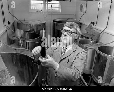 Il birraio e misurare la gravità di alcol usando un densimetro, Gran Bretagna, Regno Unito 1985 Foto Stock