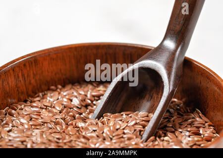 Comune di lino di lino - Linum usitatissimum - piccola ciotola di legno, closeup sul cucchiaio di legno nel mucchio di semi Foto Stock