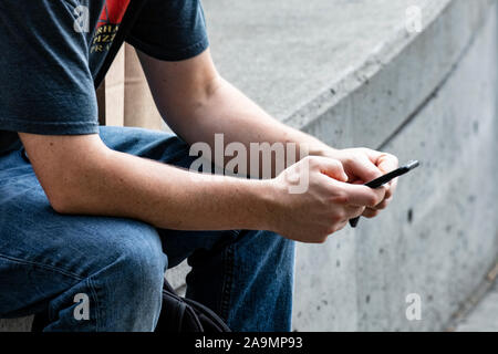 WA17344-00...WASHINGTON - Uomo con un telefono cellulare. No signor Foto Stock