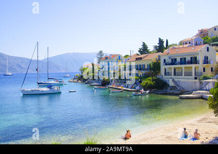 Spiaggia con barche e bagnanti a Fiscardo , Cefalonia, Grecia Foto Stock