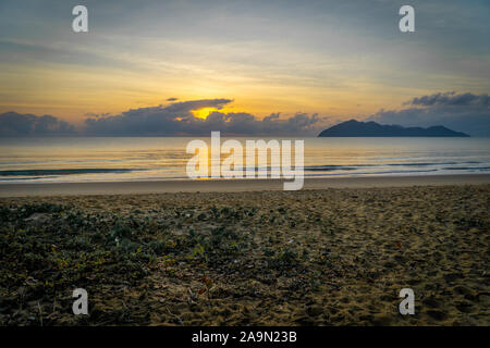 Un sunrise presso la spiaggia paradisiaca di Mission Beach a nord dell'Australia Foto Stock