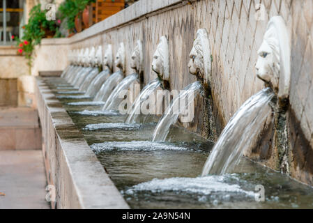 Antica fontana veneziana con teste di leoni sorgenti acqua potabile pura a Spili, Creta isola, Grecia Foto Stock