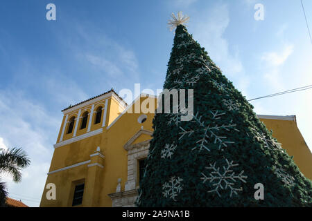 Cartagena de Indias, Bolivar/Colombia, Dicembre 10, 2017: un albero di Natale decorato ein davanti la chiesa gialla a Cartagena Foto Stock