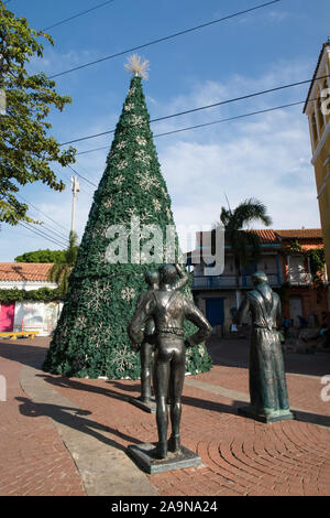 Cartagena de Indias, Bolivar/Colombia, Dicembre 10, 2017: alcune statue guardando un albero di Natale decorato su un quadrato a Cartagena Foto Stock