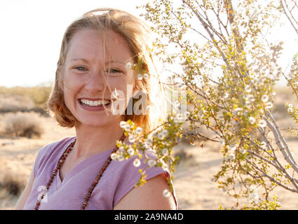 Giovane donna felice giocando lo yoga ed esprimendo fitness generale nei ritratti. Deserto Mojave Joshua Tree, CA USA Foto Stock