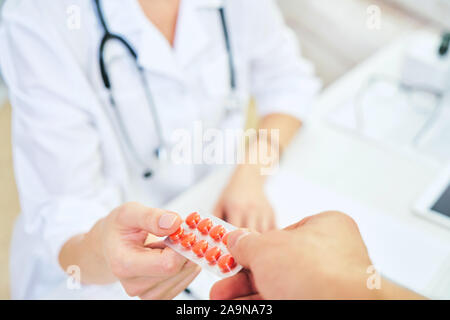 Prescrizione di un medico per il trattamento di malattie. Medico dando il blu pillole medicinali. concetto di farmacologia Foto Stock