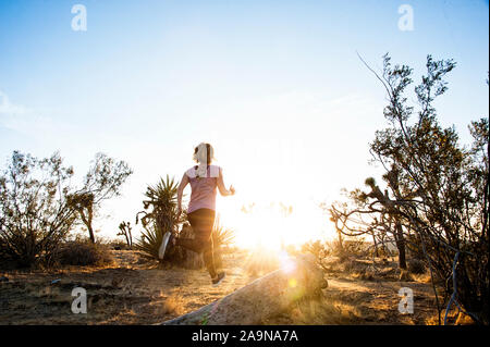 Giovane donna felice giocando lo yoga ed esprimendo fitness generale nei ritratti. Deserto Mojave Joshua Tree, CA USA Foto Stock