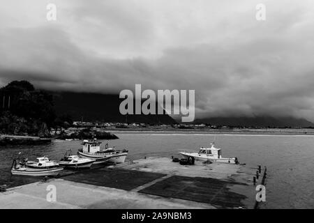 Le navi ormeggiate al porto di Chaiten sotto moody sky nel Parco Pumalin, Chaiten, Patagonia, Cile Foto Stock