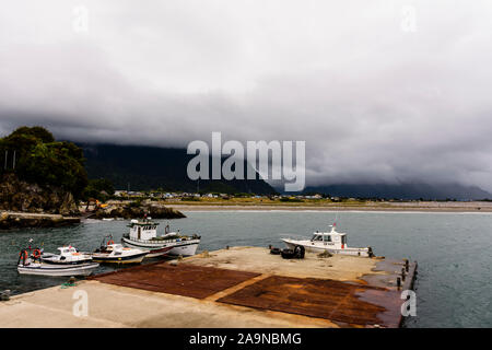 Le navi ormeggiate al porto di Chaiten sotto moody sky nel Parco Pumalin, Chaiten, Patagonia, Cile Foto Stock