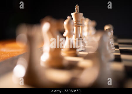 Chiudere fino a scacchi pezzi su una scacchiera, in rappresentanza di strategia e tattica Foto Stock