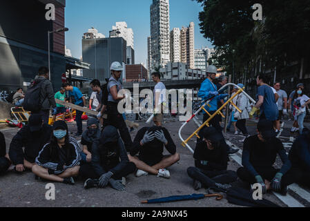 Hong Kong, Cina. Xvi Nov, 2019. Manifestanti occupano la strada mentre i residenti locali chiara degli ostacoli e detriti. Credito: SOPA Immagini limitata/Alamy Live News Foto Stock