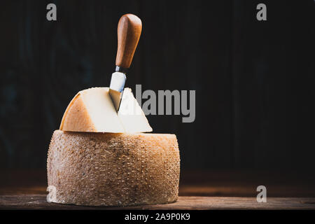 Pezzo tagliato da tutto il formaggio stagionato ruota. Il cibo tradizionale di produrre. Foto Stock