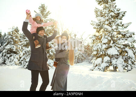 La famiglia felice con bambini in boschi innevati Foto Stock