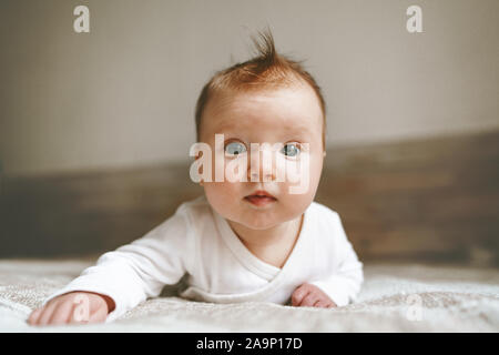 Carino neonato bambino gattona in camera da letto adorabili kid ritratto lo stile di vita della famiglia 3 mese bambino close-up Foto Stock