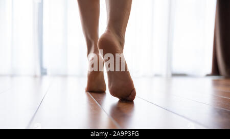 Piedini femmina camminando sul caldo pavimento riscaldato vista ravvicinata Foto Stock