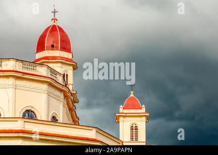 Tappata rosse torri della basilica in onore di Nostra Signora della Carità con black thunder nuvole sopra, El Cobre, Santiago de Cuba, Cuba Foto Stock