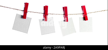 Set di quattro fogli di carta bianca note tenuto su una stringa con clothespins isolati su sfondo bianco Foto Stock