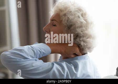 Stanco senior nonna sfregamento torcicollo che soffre di fibromialgia dolore Foto Stock