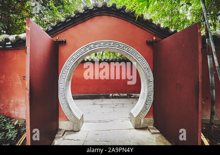 Round gate nel muro rosso passaggio, dai toni di colore immagine, tempio di Wuhou Chengdu, in Cina. Foto Stock