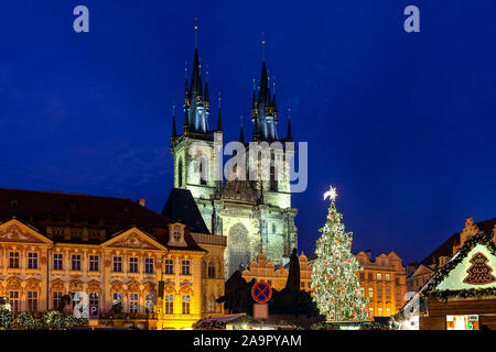 Albero di natale e la chiesa di Santa Maria di Týn al di sotto del cielo della sera nella città vecchia di Praga durante il tradizionale mercato di Natale. Foto Stock