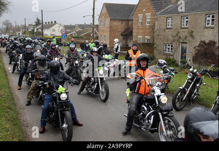 Un convoglio di moto rende il modo attraverso il villaggio di Charlton come essi seguono Harry Dunn's Last ride come un omaggio al figlio adolescente morto quando il suo moto è stato coinvolto in una collisione frontale esterno passa RAF Croughton, Northamptonshire, in agosto. Foto Stock