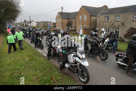 Un convoglio di moto rende il modo attraverso il villaggio di Charlton come essi seguono Harry Dunn's Last ride come un omaggio al figlio adolescente morto quando il suo moto è stato coinvolto in una collisione frontale esterno passa RAF Croughton, Northamptonshire, in agosto. Foto Stock