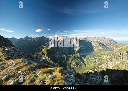 Picchi di alta sopra la valle nelle montagne Tatra. I Monti Tatra sono le vette più alte dei Carpazi sulla frontiera polacco-slovacca. Foto Stock