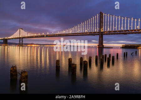 Vista di Oakland Bay Bridge nelle prime ore del mattino dal molo vicino a Rincon Park di San Francisco, California Foto Stock