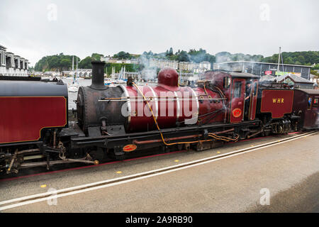 Welsh Highland treni che arrivano a Porthmadog da Caernarfon andare giù il High Street per una breve distanza Foto Stock