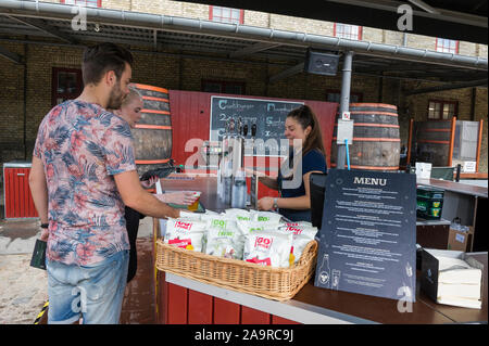 Un barista che serve birra per un paio presso la fabbrica di birra Carlsberg, Copenhagen, Danimarca Foto Stock
