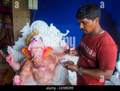 Uomo indiano che decora l'idolo di Ganesh per il festival di Chaturthi di Ganesh in India di Mumbai Foto Stock